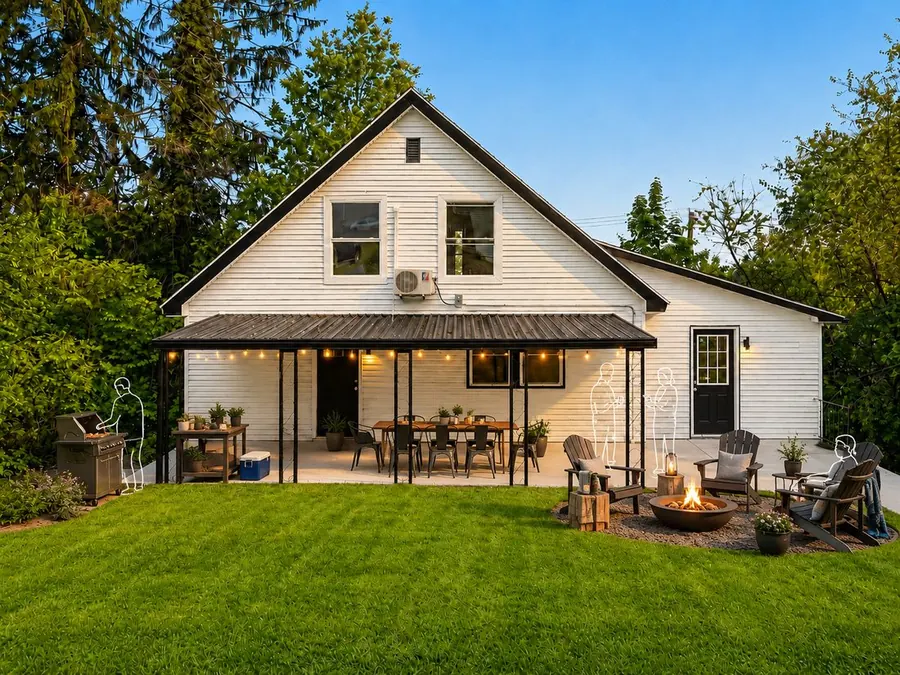 The backyard staged for a barbecue with a fire pit, grill and white line-drawn figures for people
